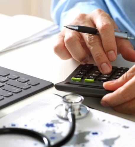 Hand of smart doctor used a calculator for medical costs in modern hospital